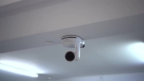 Rotating White Surveillance Camera on Ceiling