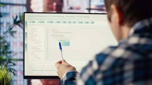 Programmer at Desk Typing Code Into Computer Developing Software Programs