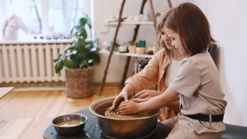Woman and Child Working Together to Create Clay Pot