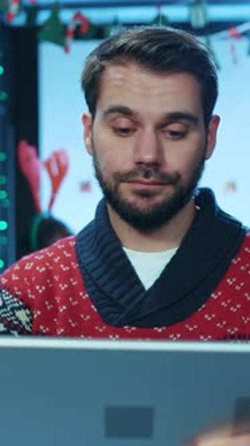 A Joyful Man in a Cozy Sweater Using a Tablet While Surrounded By Festive Decorations