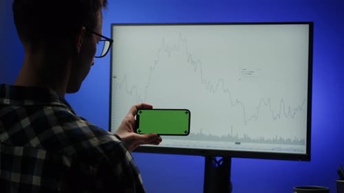Man Using Computer in Office Programmer Using Phone with Chroma Key Green Screen Professional