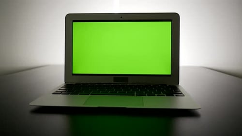 isolated green screen on laptop computer display. modern office desk table view
