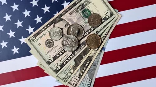 US Currency and Coins Displayed on American Flag