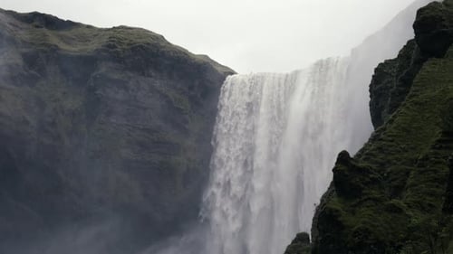 Weitwinkelaufnahme eines riesigen Wasserfalls, der über dem Abgrund des Untergangs Wasser herabprasselt. In glorreicher Langsamkeit gedreht