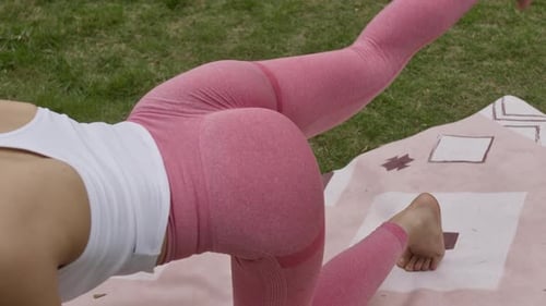 Female asiatic model woman workout yoga leg and buttocks exercises outdoor in park