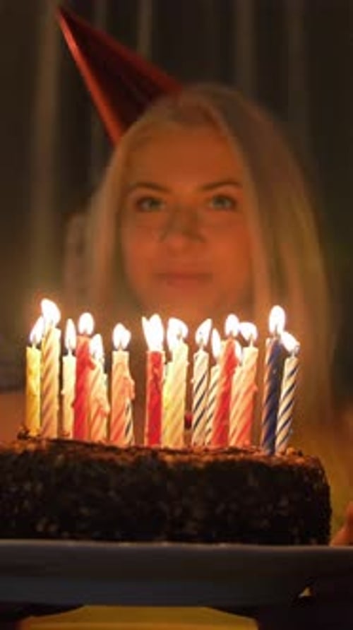 Smiling Person Holds Birthday Cake With Candles