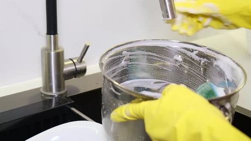 Hands in Gloves Cleaning Stainless Steel Pot