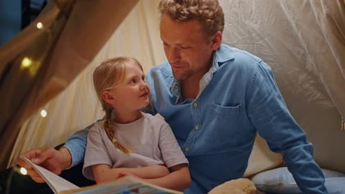Father and Child Reading Together in Cozy Tent
