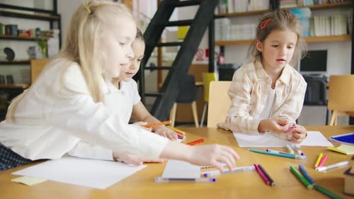 Elementary School Children are Fully Engaged in an Art Class Drawing and Coloring with Pencils and