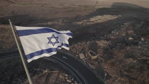 Israeli Flag Waving Beside Winding Rural Road