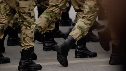 Closeup View of Uniformed Soldiers' Legs in Camouflage Trousers and Combat Boots Marching in