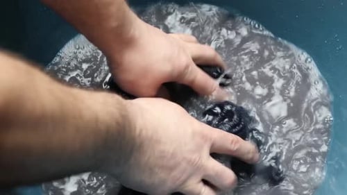 16k. Socks are washed in a large bowl of soapy water. Homework concept.