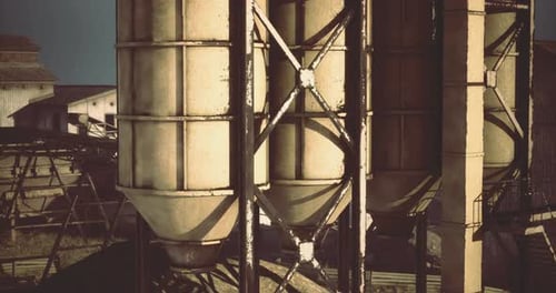Industrial Grain Silos at a Farm During Golden Hour in Rural Landscape