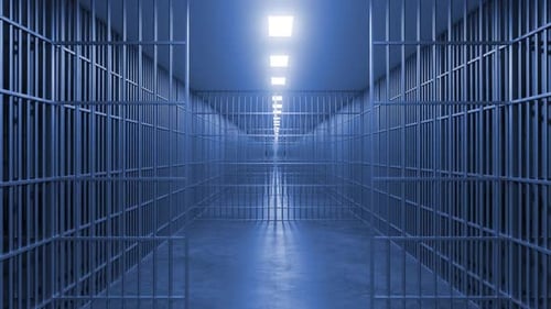 Gefängniskorridor mit Metallstäben und künstlichem Licht