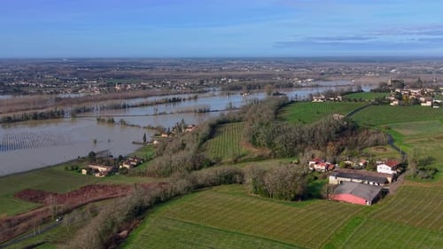 Aerial view of floodwaters submerge a landscape of vineyards and a lone building