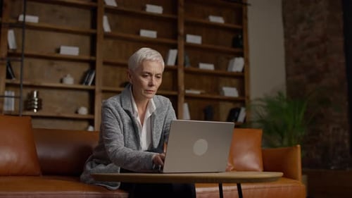 Mature Businesswoman Working on Laptop in Cozy Office