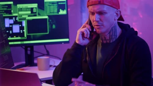 Man Talking on Phone While Using Computer