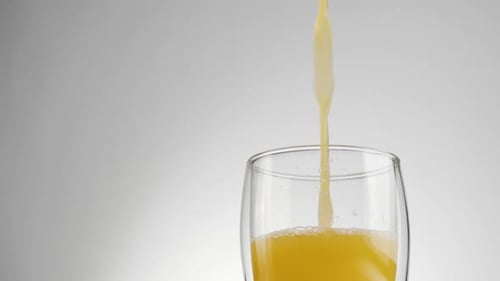 Orange Juice Poured into Glass Close Up
