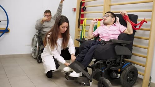Therapist Helping Man in Wheelchair at Physical Therapy