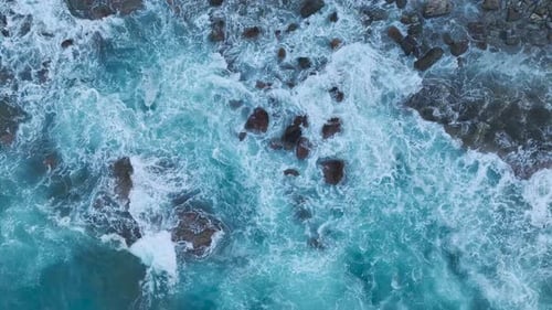 Aerial View Rough Sea Crashing on Rocky Shore at Sunrise Ocean Waves and Textures