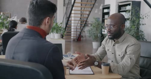 Businesspeople Discussing Deal Then Shaking Hands Making Agreement After Talks in Coworking Office
