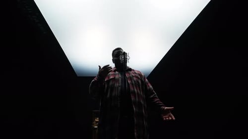 Man Singing into Microphone in Dark Studio
