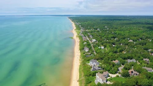 Drone Shot of Wide Sandy Beach with Umbrellas, Boats, and Families