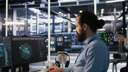 Un técnico de centro de datos sonriente usa una PC para monitorear redes neuronales