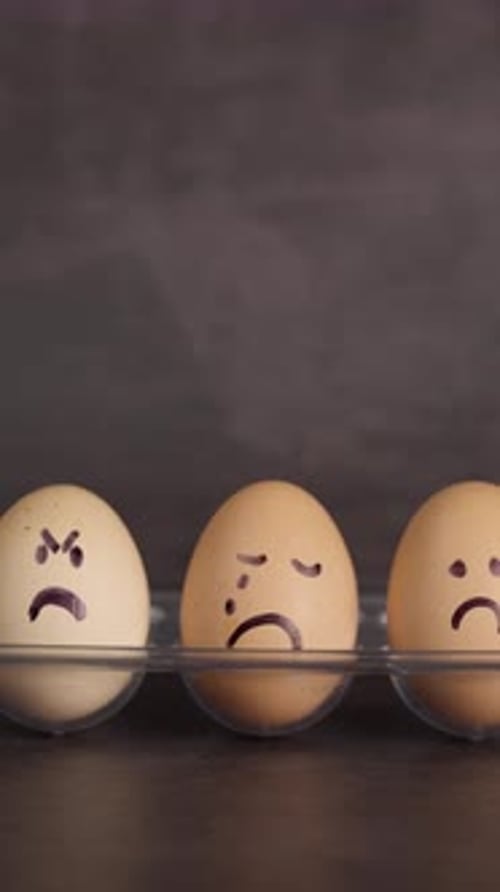 Eggs with Drawn Sad Faces Sit Side By Side