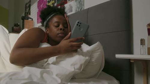 Young Adult Wakes Up With Smartphone in Bed