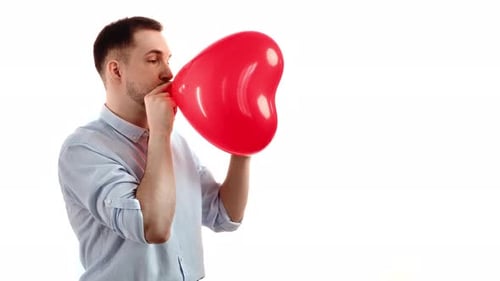 Man Inflating Heart Balloon on White Background