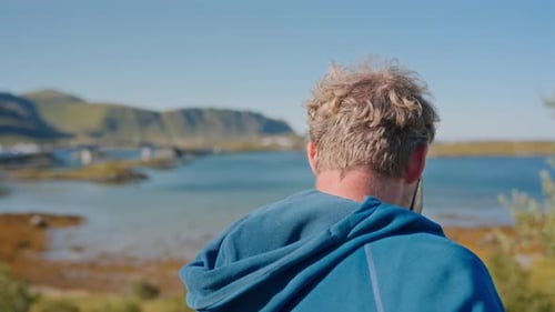 Man In Blue Hoodie Filming A Distant Bridge
