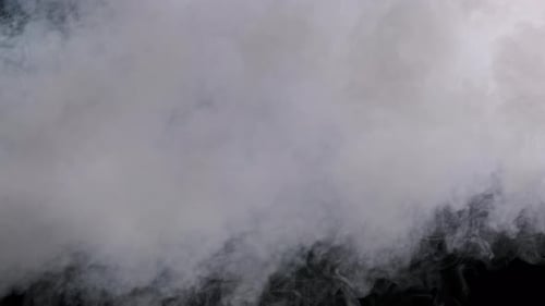 Humo blanco sobre un fondo negro en una explosión de vapor a cámara lenta