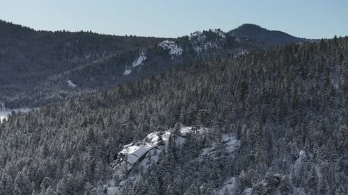Winter Christmas wonderland frosty Rocky mountainside snowy meadow valley aerial drone Conifer Everg