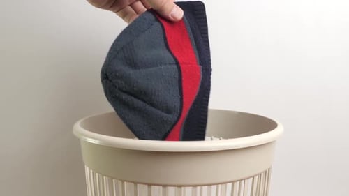 Knit Hat Dropped into Waste Basket Close Up