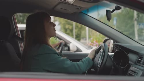 Woman Driving Car Through the City Streets