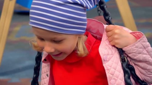 playground, fun - beautiful little blonde girl smiles playing on the swing
