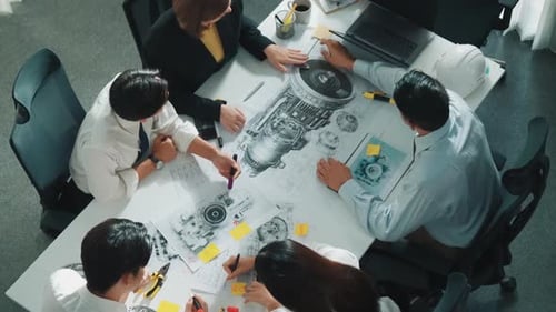 Engineers Discussing Blueprints at Desk Overhead Shot