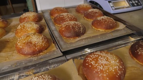 Closeup of Freshly Baked Burger Buns with Sesame Seeds in the Restaurant Kitchen