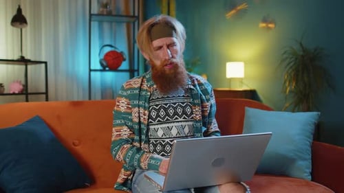 Frustrated Man Working on Laptop at Home