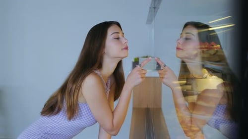 young girl is choosing food from the bakery cabinet. There are various desserts in the fridge. 4K. t