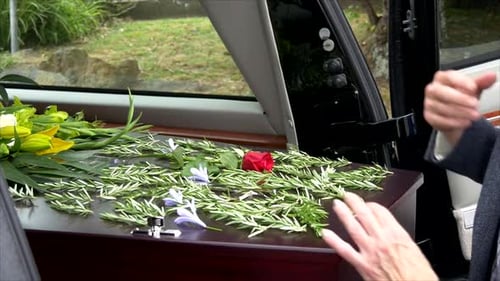 closeup shot of a funeral casket in a hearse or chapel or burial at cemetery