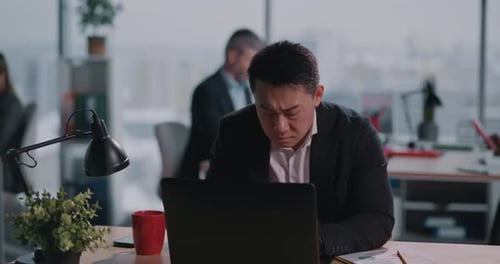 Stressed man sitting at desk in office