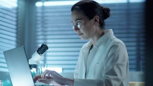 Scientist Working on Laptop in Modern Laboratory
