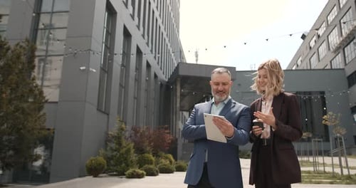 Business Colleagues Discussing on Tablet Outside Office