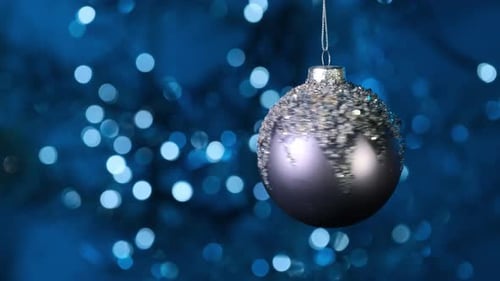Beautiful Shiny Christmas Ball Ornament Hanging on Tree Branch with Golden Bokeh