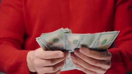 Hands Counting Stack of US Hundred Dollar Bills