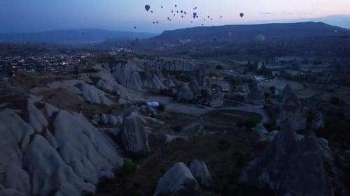 Dawn in Cappadocia with balloons floating over striking rock formations