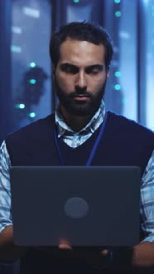A Focused Professional Engaged in Working on a Laptop Within a Modern Office Environment