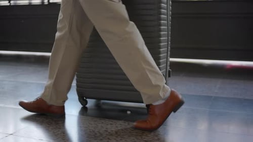 A Business Traveler with Luggage is Seen in a Modern Airport Setting Ready for Their Journey